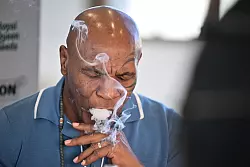 Mike Tyson, Boxer und Unternehmer, rauchte am Freitag an einem Stand der Cannabis-Messe Mary Jane einen Joint. - © Sebastian Gollnow/dpa