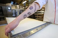 Liebt seinen Beruf sichtlich: Brot-Sommelier Florian Lutz trägt zu seiner Passion passende Tattoos. - © Christoph Schmidt/dpa-tmn