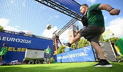 Ein Besucher versucht beim Fanfest im Nordsternpark einen Fu&szlig;ball in eine Bergbau-Lore zu kicken. - &copy; Julian Stratenschulte/dpa