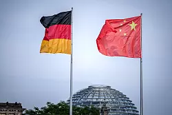Die Flaggen von Deutschland und China wehen vor dem Bundeskanzleramt. Im Hintergrund die Kuppel des Reichstagsgeb&auml;udes. - &copy; Kay Nietfeld/dpa