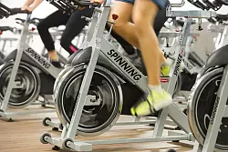 Indoorcycling statt Rennradrunde draußen: Bei Sommerhitze ist es sinnvoll, das Training ins gut klimatisierte Fitnessstudio zu verlegen. - © Tobias Hase/dpa-tmn