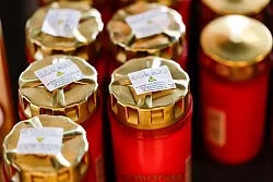 In einer Friedhofsgärtnerei stehen Grablichter zum Verkauf in einem Regal. - © Thomas Banneyer/dpa