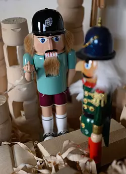 Hölzerner Rebell: Der erzgebirgische Nussknacker zeigt Billigkopien aus Fernost den Stinkefinger. - © Hendrik Schmidt/dpa