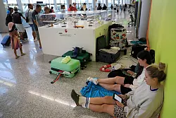 Reisende strandeten auf dem Flughafen und mussten die Nacht auf Decken und Luftmatratzen verbringen. - © Clara Margais/dpa