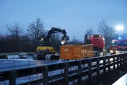 Ein Bagger r&auml;umt Tr&uuml;mmerteile nach einer Unfallserie bei Gl&auml;tte mit mehreren Toten und vielen Verletzten auf der A44 von der Fahrbahn. - &copy; Christian M&uuml;ller/dpa