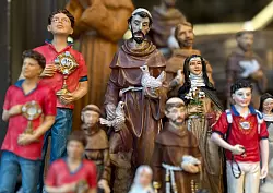 Figuren des alten und des neuen Heiligen stehen in Souvenirshops nebeneinander. (Archivbild) - &copy; Christoph Sator/dpa