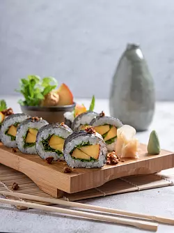 Die Algenblatt- und Reisgrundlage von Maki-Sushi kann jeweils saisonal passend gefüllt werden: hier mit Pfirsich und Basilikum. - © Alex Neumayer/Christian Verlag/dpa-tmn