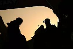 T&uuml;rkische Rettungskr&auml;fte stehen an einem eingest&uuml;rzten Geb&auml;ude. - &copy; Emrah Gurel/AP/dpa