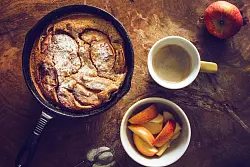 Luftige Leckerei aus dem Backofen: Für den Pancake wird der Teig über die Apfelscheiben gegossen und in der Röhre gebacken. Mehr Süße ist nicht drin, kann aber später durch Ahornsirup oder Puderzucker ergänzt werden. - © Aileen Kapitza/minzgruen.com/dpa-tmn