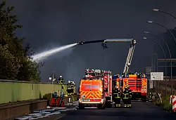 Einsatzkräfte der Feuerwehr versuchen, einen Brand in einem Industriegebiet im Hamburger Hafen zu löschen. - © Daniel Bockwoldt/dpa