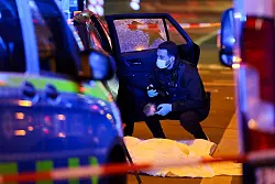 Ein Beamter der Polizei untersucht den Tatort. - © Christoph Reichwein/dpa