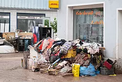 Vom Hochwasser zerstörter Hausrat vor einem Einzelhandelsgeschäft in Rudersberg. - © Marijan Murat/dpa