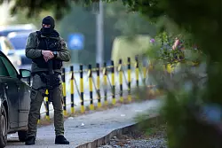 Ein Polizeibeamter steht neben dem Schauplatz eines Anschlags in dem Dorf Dubona, etwa 50 Kilometer südöstlich von Belgrad, Wache. - © Armin Durgut/AP