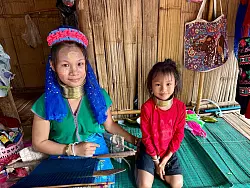 Die Langshalsfrauen und ihre Kinder sind daran gew&ouml;hnt, f&uuml;r Touristenfotos in die Kameras zu l&auml;cheln. - &copy; Carola Frentzen/dpa