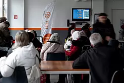 Tafelkunden warten an der Lebensmittelausgabe, bis ihre Nummer an der Reihe ist - Schlangestehen ist in vielen NRW-Tafeln nicht mehr notwendig. - &copy; Fabian Strauch/dpa