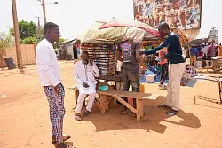 M&auml;nner stehen auf einem Stra&szlig;enmarkt in Niamey. - &copy; Sam Mednick/AP/dpa