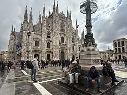 Trotz Rauchverbots sitzen zwei Männer mit Zigaretten in der Hand vor dem Mailänder Dom. - © Christoph Sator/dpa