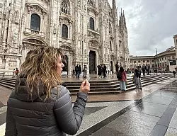 Eine Touristin mit Zigarette in der Hand vor dem Dom in Mailand. - © Christoph Sator/dpa
