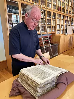 Mit alten Quellen: Kathedralen-Archivar Vicente Pons zeigt ein Registerbuch, das die Übergabe des Grals an die Kathedrale belegen soll. - © Manuel Meyer/dpa-tmn