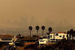 Die ganze Skyline von Los Angeles war von Rauch umgeben. - © Etienne Laurent/AP/dpa