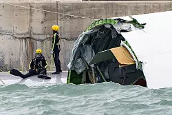Ein Sicherheitsmitarbeiter wurde tot aus dem Wasser geborgen. - © Chan Long Hei/AP/dpa