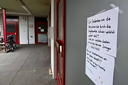 Anwohner drücken ihre Anteilnahme aus nach der Explosion einer Kugelbombe zu Silvester, die mehrere Menschen zum Teil schwer verletzt hat. - © Jens Kalaene/dpa