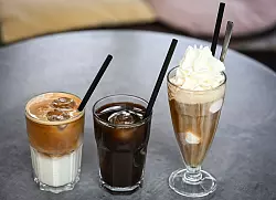 Iced Latte (also geeister Milchkaffee) und Iced Coffee sind puristischer als der sahnige Wiener Eiskaffee, der früher der Inbegriff von Eiskaffee in Deutschland war. - © Jens Kalaene/dpa