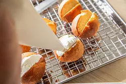 Aus Puderzucker, echter Vanille und Vollrahm wird die Creme hergestellt, die als Füllung in die herausgeschnittenen Slots der Maritozzo Romano gefüllt wird. - © Christin Klose/dpa-tmn