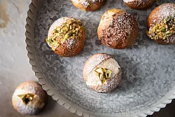 Diese fluffigen Milchbrötchen mit Cremefüllung werden Maritozzo Romano genannt. Sterneküchenmäßig werden sie mit Blattgold, Schokolade und Pistazien dekoriert. - © Christin Klose/dpa-tmn