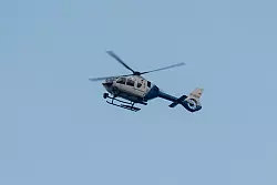 Ein Polizeihubschrauber fliegt über den Ortsrand in Parsberg. - © Armin Weigel/dpa