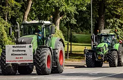 Ein Traktor mit einem Plakat mit der Aufschrift «Wohlstand Ernährung Klimaschutz nur mit heimischer Landwirtschaft» fährt zum Auftakt der Agrarministerkonferenz durch die Kieler Innenstadt. - © Axel Heimken/dpa