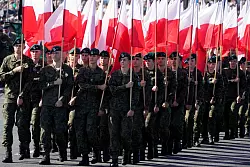 Soldaten tragen polnische Nationalfahnen w&auml;hrend einer Milit&auml;rparade am Tag der polnischen Streitkr&auml;fte. - &copy; Czarek Sokolowski/AP/dpa