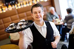 Er will mit seinen Gästen ins Gespräch kommen: Vincenzo Bozzato von der Café-Bar 8tto Grammi in Bayreuth. - © Daniel Karmann/dpa