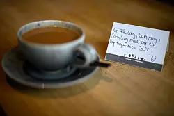 Schilder auf den Tischen weisen im Cafe «Thies Wohnen und Leben» in Magdeburg auf die laptopfreien Tage hin. - © Klaus-Dietmar Gabbert/dpa