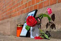 Stilles Gedenken am Bahnhof Friedland: Rosen und Kerze erinnern an die verstorbene Jugendliche. - © Swen Pförtner/dpa