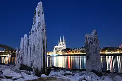 Teile einer Holzkonstruktion, die normalerweise unter Wasser liegen, sind am Rhein gegenüber vom Kölner Dom zu sehen. - © Federico Gambarini/dpa