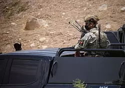 Sicherheitskräfte der kurdischen Regionalverwaltung sichern den Ort, wo die Waffenniederlegung stattfand. - © Hadi Mizban/AP/dpa