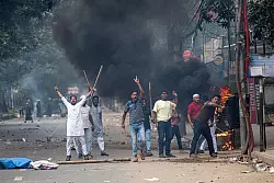 Studenten stehen bei dem Protest in Dhaka Polizisten gegenüber. - © Rajib Dhar/AP/dpa
