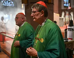 Rainer Maria Woelki (r) und Reinhard Marx sind zwei der drei deutschen Kardinäle, die den neuen Papst mitwählen. (Archivbild) - © Arne Dedert/dpa