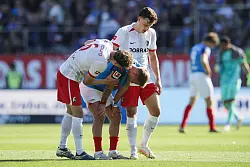 Kiels Lewis Holtby wird nach dem Abstieg von den Freiburgern Patrick Osterhage (l) und Maximilian Eggestein getröstet. - © Claus Bergmann/dpa