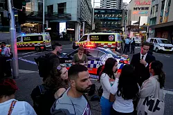 Eine Menschenmenge versammelt sich vor dem Westfield Shopping Centre. Medienberichten zufolge wurden in dem Einkaufszentrum in Sydney mehrere Menschen niedergestochen und eine Person von der Polizei erschossen. - &copy; Rick Rycroft/AP