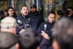 Polizeibeamte sprechen mit m&ouml;glicherweise betroffenen Kunden der Sparkassenfiliale in Buer. - &copy; Christoph Reichwein/dpa