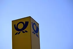 Das Posthorn-Logo ist am Kölner Briefzentrum zu sehen. - © Federico Gambarini/dpa