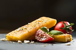Wer keinen Polenta-Brei mag, kann daraus auch Schnitten machen. Einfach breit streichen, abkühlen lassen und braten. Dazu passen Tomaten, Feta und Basilikum. - © Franziska Gabbert/dpa-tmn