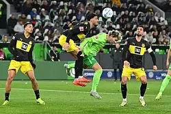 Wolfsburgs Jonas Wind bedrängt von gleich drei Dortmundern. - © Swen Pförtner/dpa