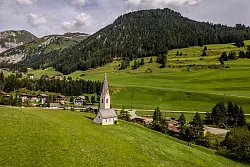 Blickfang auf der grünen Wiese: die Kapelle St. Georg in Kals am Großglockner. - © Peter Maier/Tirol Werbung/dpa-tmn