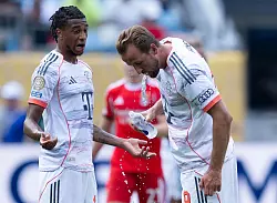 Harry Kane (r) kühlt sich mit Wasser von innen. - © Sven Hoppe/dpa