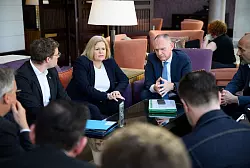 Nancy Faeser (SPD), geschäftsführende Bundesministerin für Inneres und Heimat, und Gerhard Karner (ÖVP), Innenminister von Österreich, informieren in einem Hotel in Amman die Mitglieder ihrer Delegationen über den Abbruch ihrer Reise nach Damaskus. - © Bernd von Jutrczenka/dpa