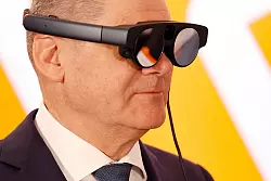 Bundeskanzler Olaf Scholz mit eier AR-Datenbrille (Augmented Reality) zur Prozess&uuml;berwachung einer Maschine. - &copy; Michael Matthey/dpa