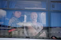 Ein ukrainischer Soldat hält das Foto eines getöteten Kameraden an das Fenster eines Busses. - © Kay Nietfeld/dpa